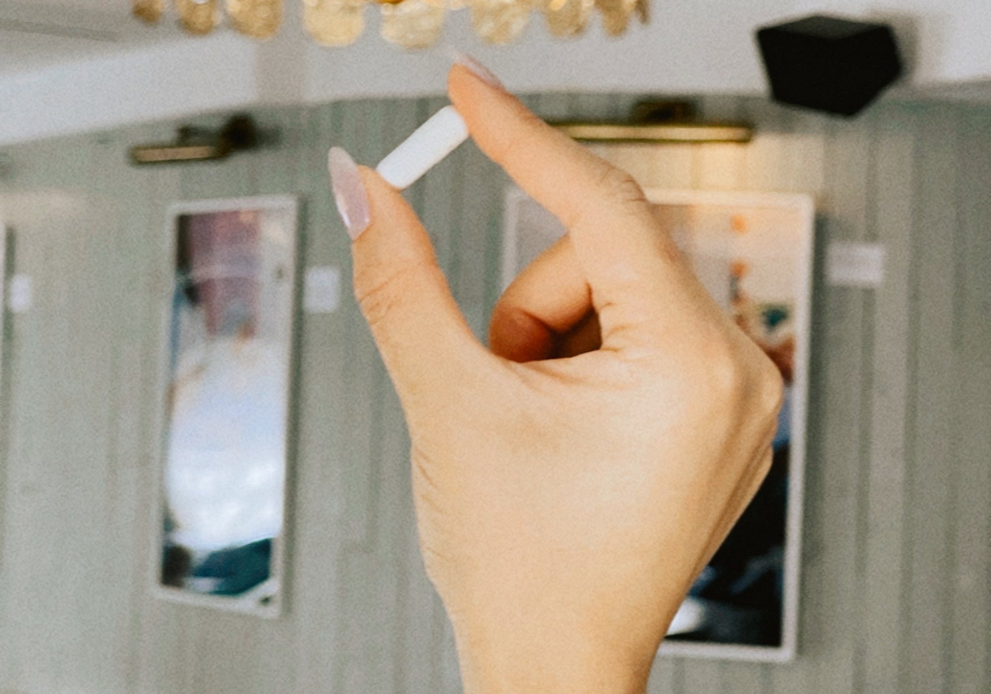 woman's hand holding supplement pill